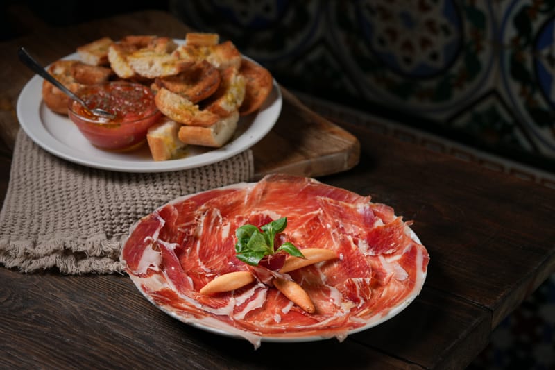 Ración de jamón ibérico con pan caliente y tomate